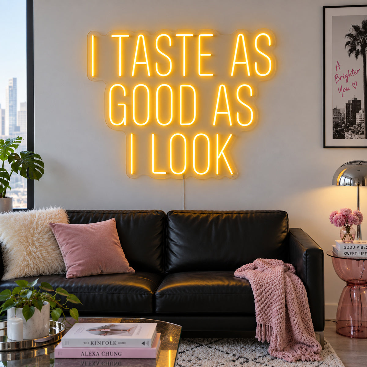 I Taste As Good As I Look Neon Sign glowing gold above a black sofa.