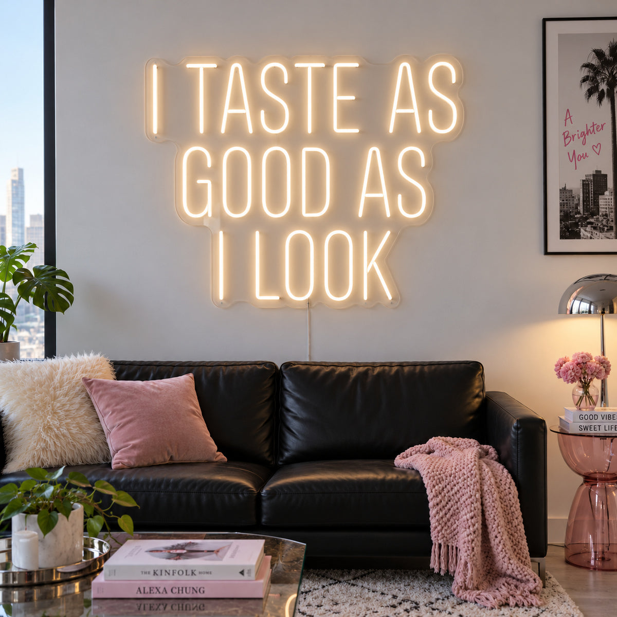 Warm White version of the I Taste As Good As I Look Neon Sign, shown above a black sofa.