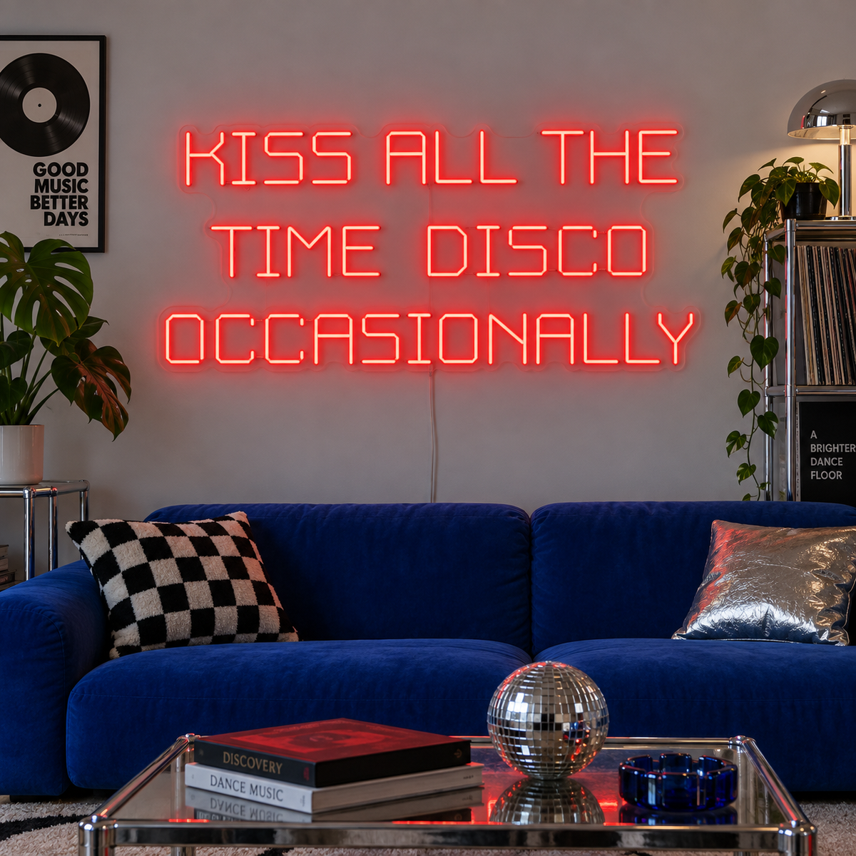 Kiss All The Time Disco Occasionally Neon Sign in red above a blue sofa near a disco ball.