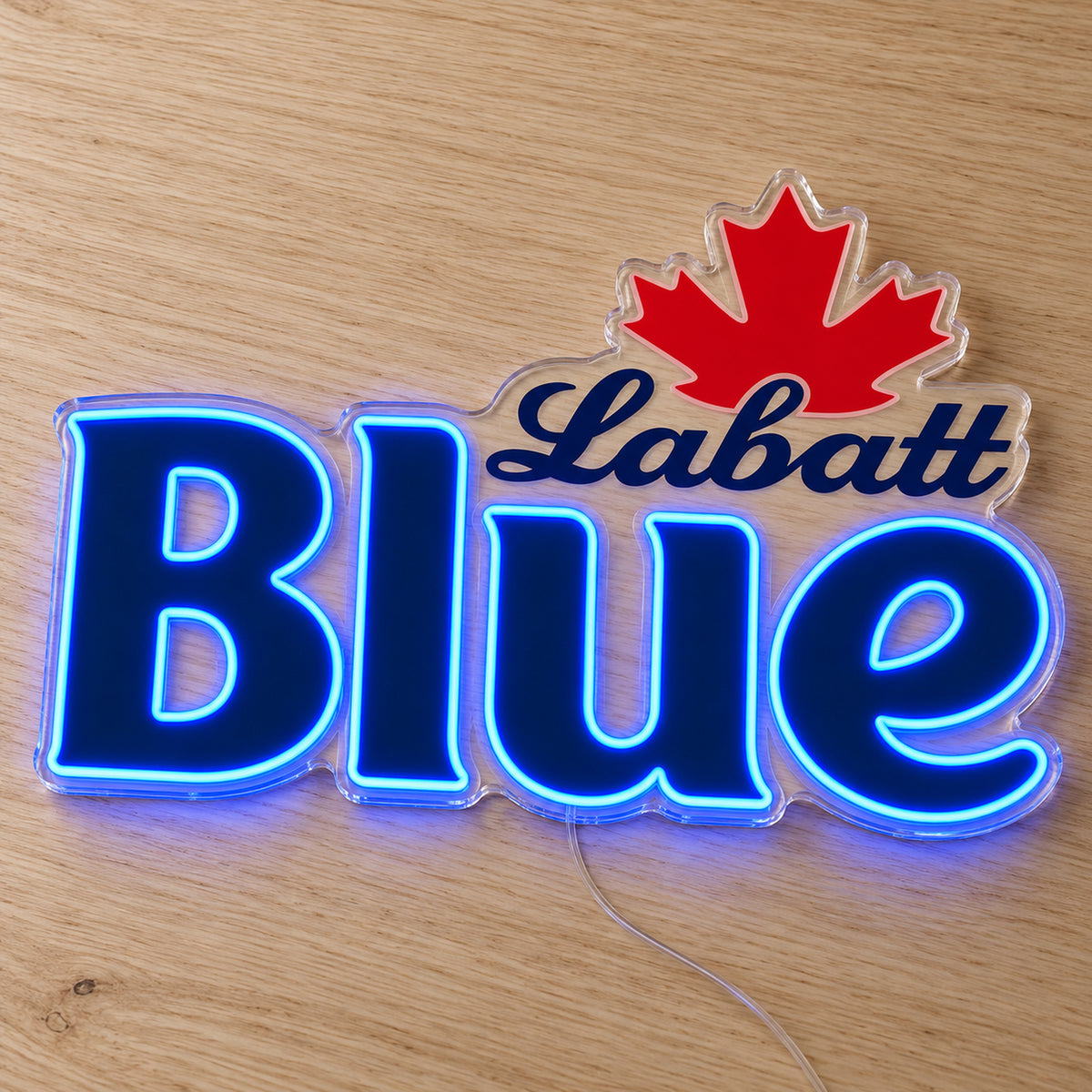 Labatt Blue LED neon sign on a light wooden surface, front view