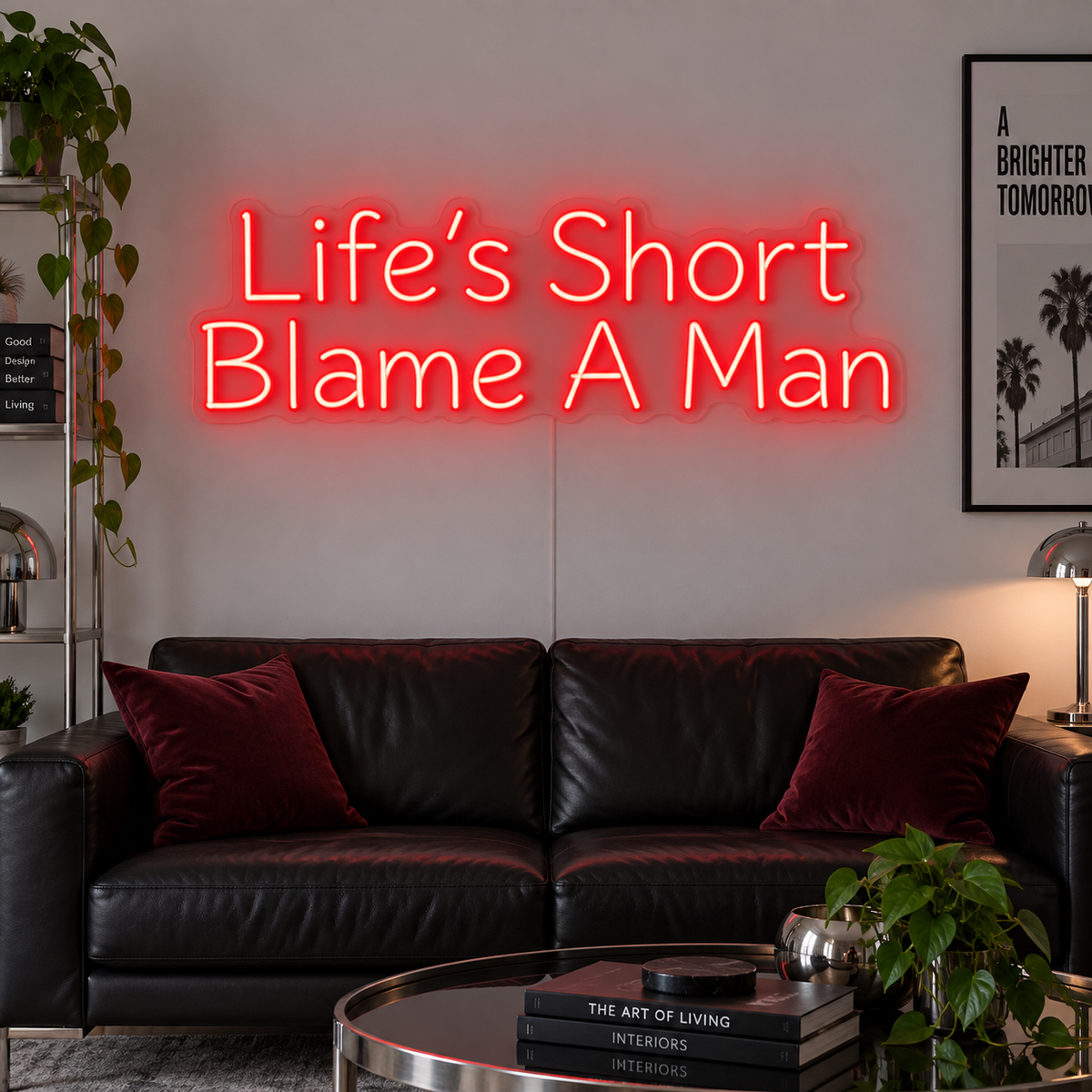 Life's Short Blame A Man Neon Sign in red above a black leather sofa.
