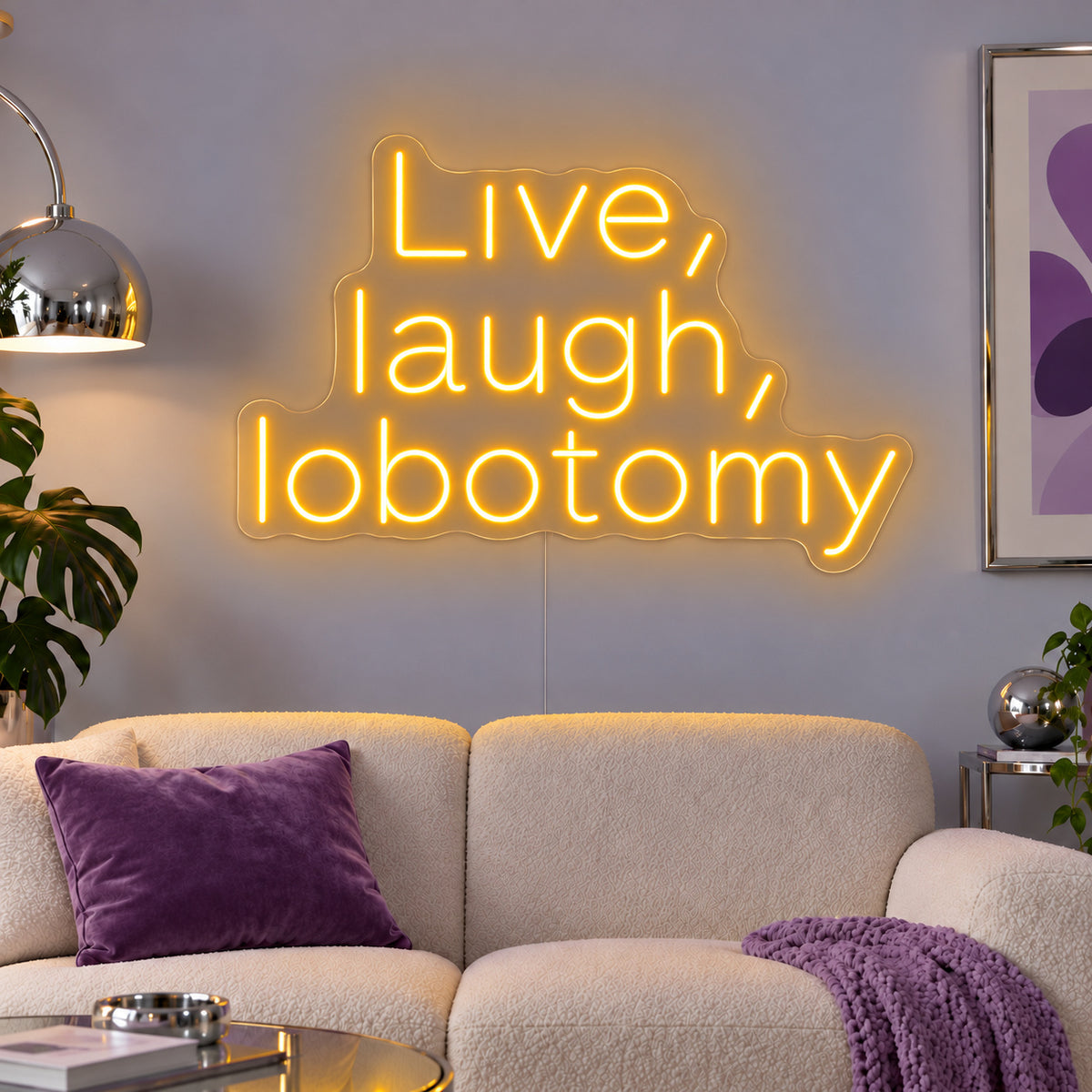 Live, Laugh, Lobotomy Neon Sign glowing gold above a cream sofa with purple cushions.