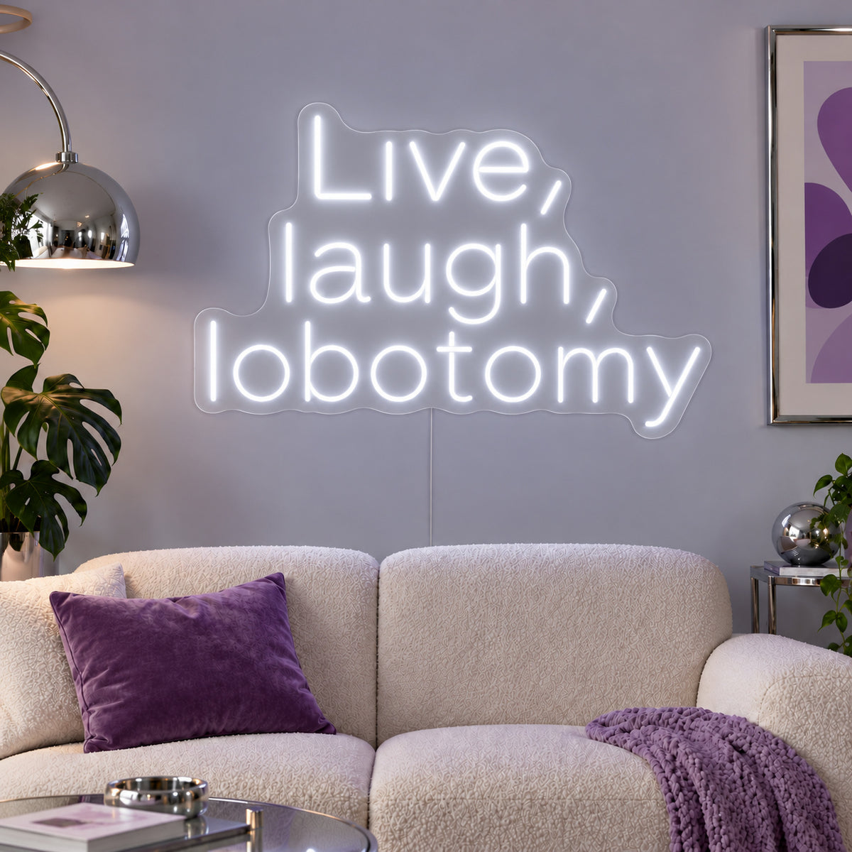 Live, Laugh, Lobotomy Neon Sign, RGB colour-changing option shown in white above a cream sofa with purple cushions.