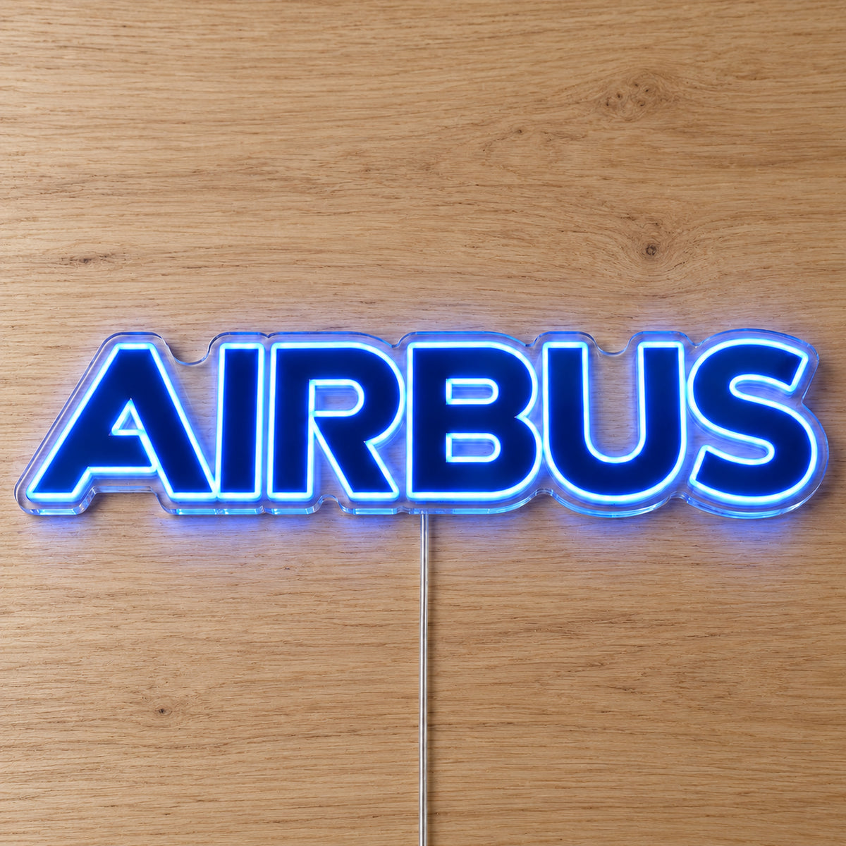Airbus Logo Neon Sign with blue LED lettering on clear acrylic, shown on a wooden surface