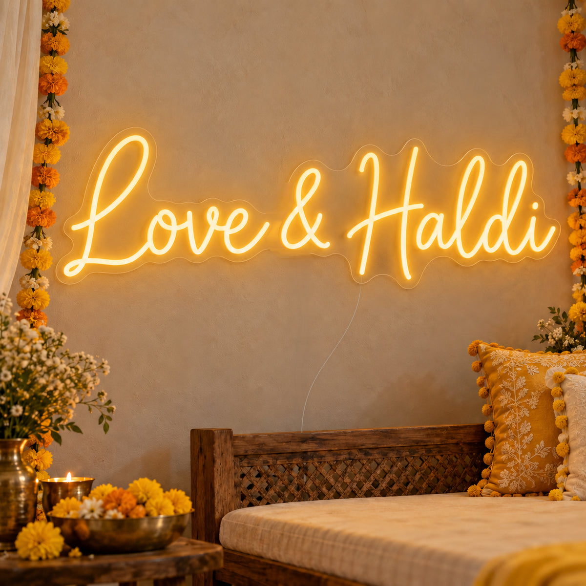 Love Haldi Neon Sign on clear cut-to-shape acrylic, illuminated on a wall in a styled celebration setting