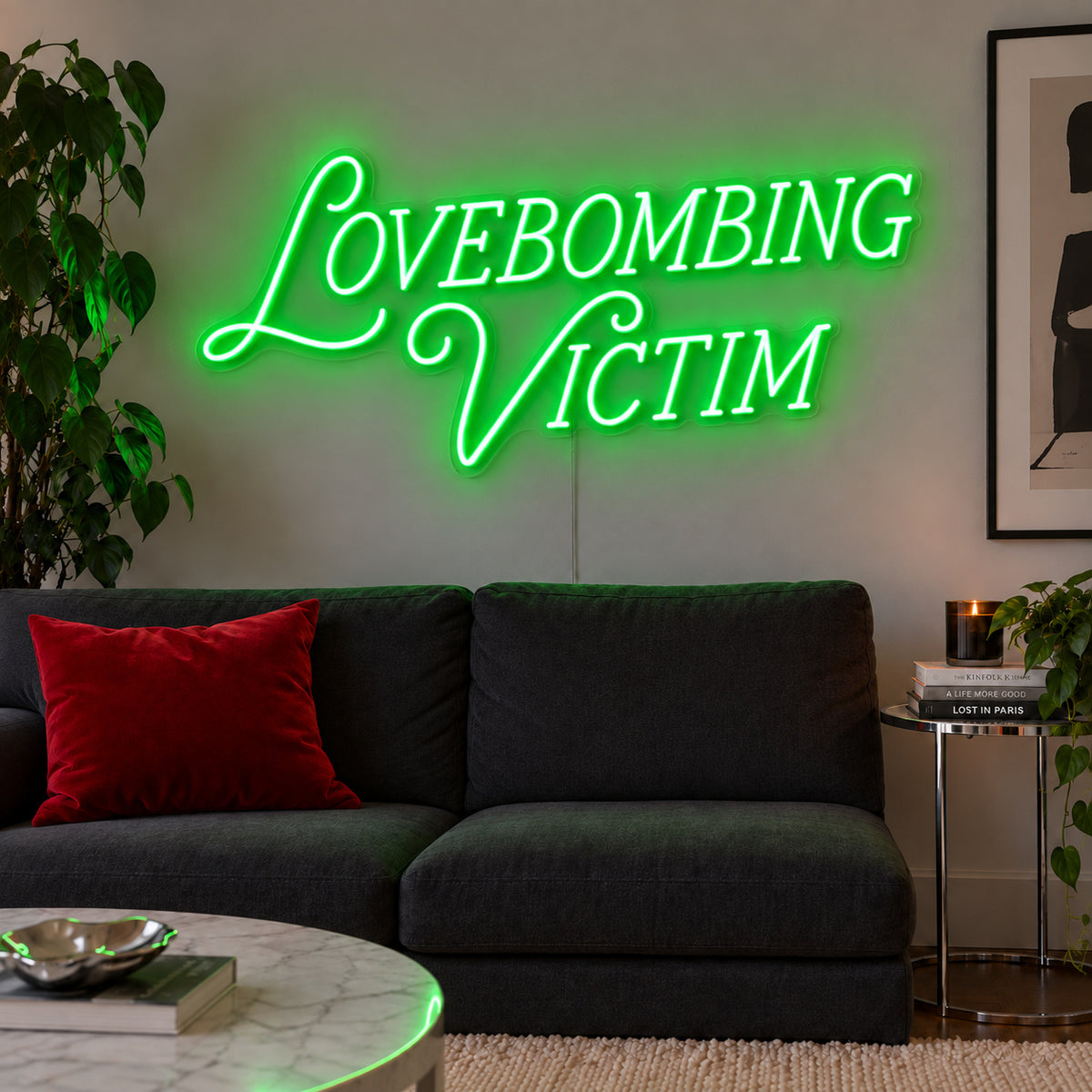 Lovebombing Victim Neon Sign with green lighting, displayed above a dark sofa with red cushions.
