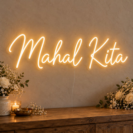 Mahal Kita Neon Sign on clear cut-to-shape acrylic, illuminated on a wall in a styled celebration setting