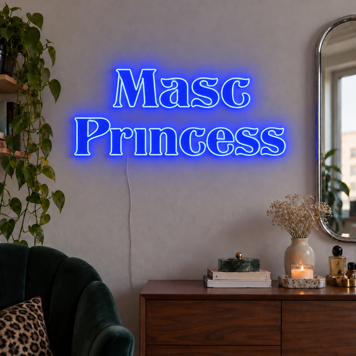 Masc Princess Neon Sign glowing blue above a wooden sideboard beside a green chair.