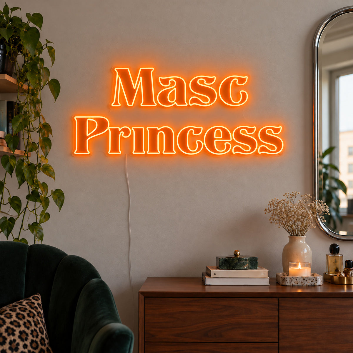 Orange version of the Masc Princess Neon Sign, shown above a wooden sideboard beside a green chair.