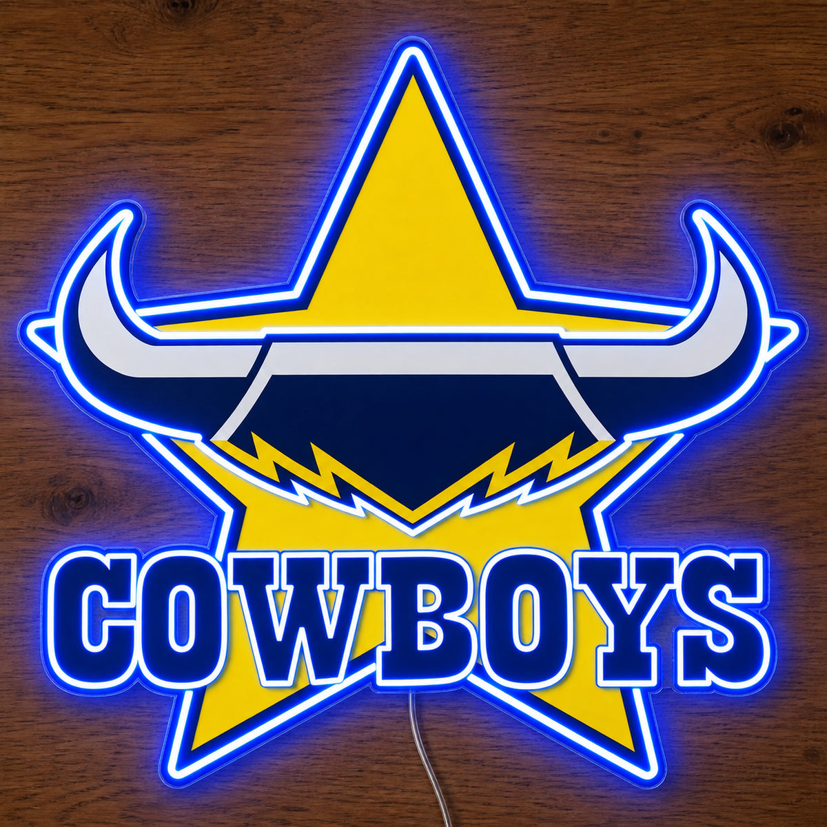 North Queensland Cowboys neon sign glowing brightly on a wooden surface in dim lighting