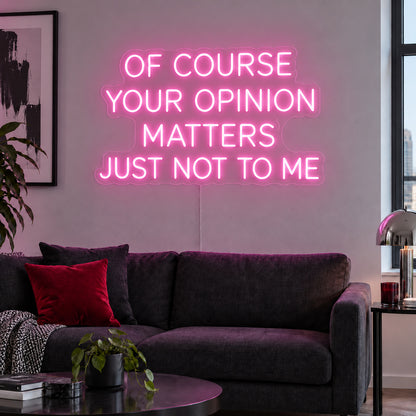 Of Course Your Opinion Matters Just Not To Me Neon Sign glowing pink above a black sofa.