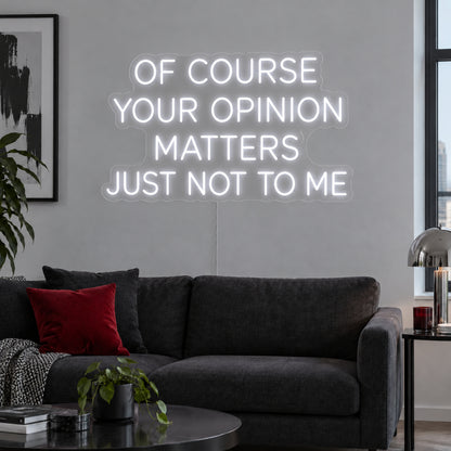 Of Course Your Opinion Matters Just Not To Me Neon Sign, RGB colour-changing option shown in white above a black sofa.