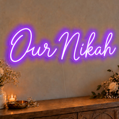 Our Nikah Neon Sign in purple LED neon on clear acrylic, angled view