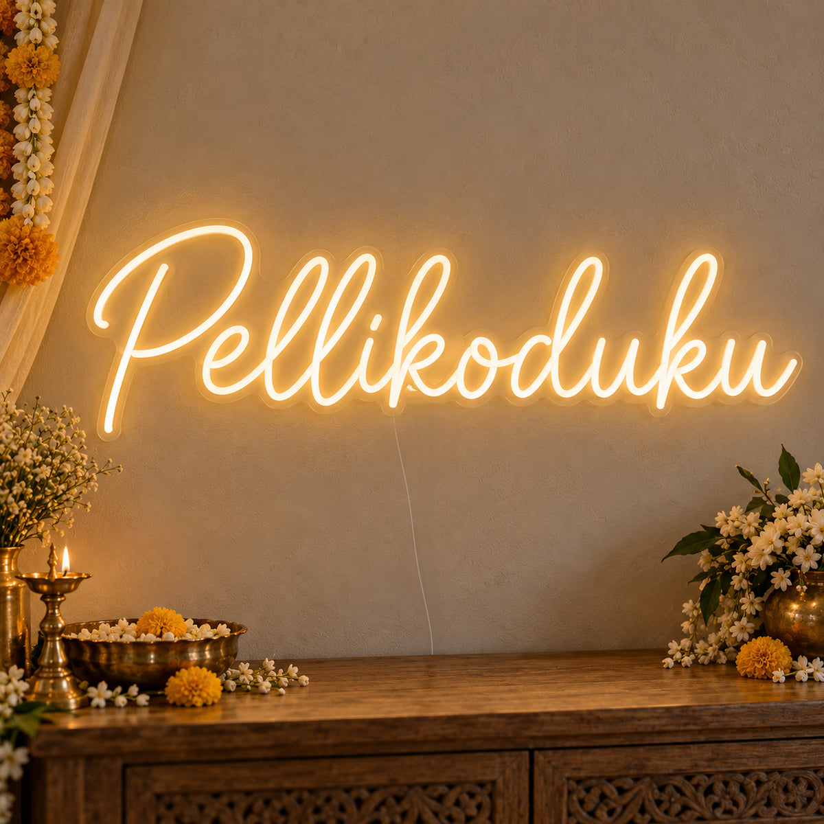 Pellikoduku Neon Sign on clear cut-to-shape acrylic, illuminated on a wall in a styled celebration setting
