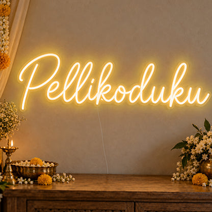 Pellikoduku Neon Sign in gold LED neon on clear acrylic, angled view