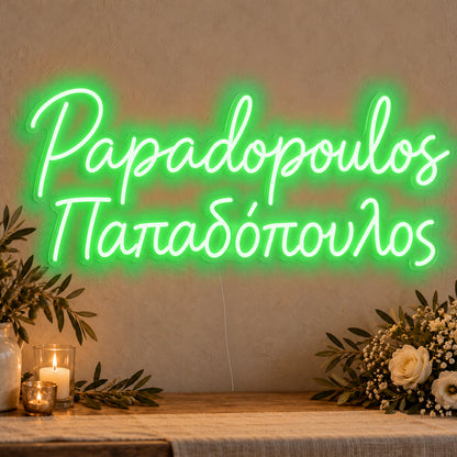 Personalised Bilingual Greek Surname Neon Sign in green LED neon on clear acrylic, angled view
