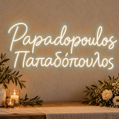 Personalised Bilingual Greek Surname Neon Sign in warm white LED neon on clear acrylic, angled view