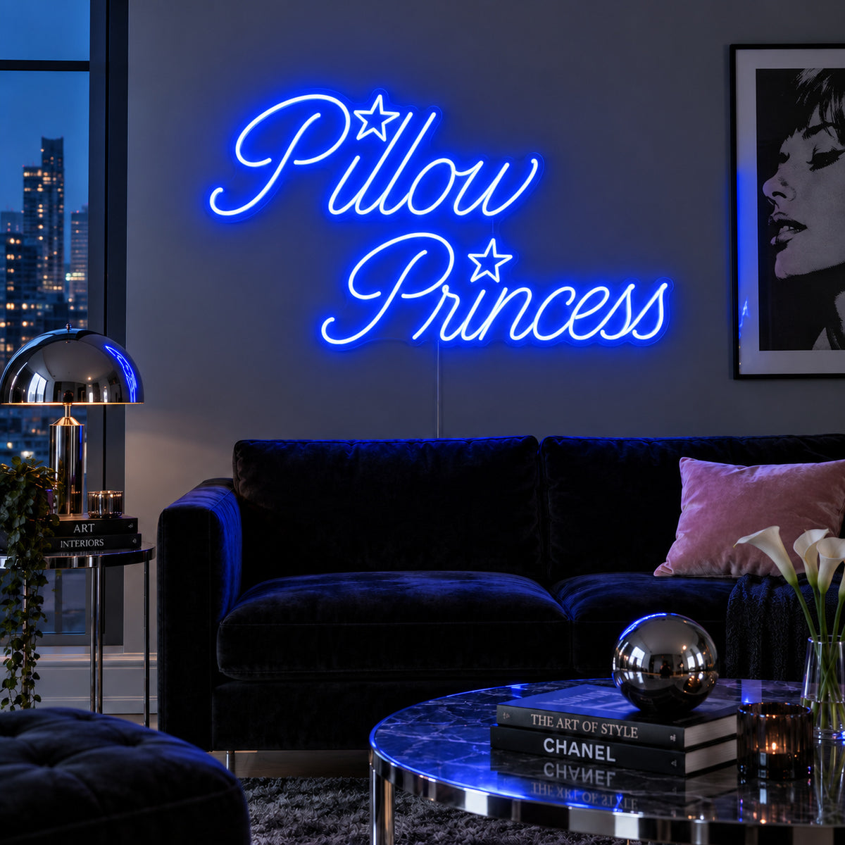 Pillow Princess Neon Sign glowing blue with star details above a dark purple sofa.