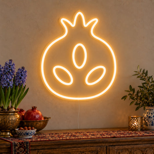 Pomegranate Neon Sign on clear cut-to-shape acrylic, illuminated on a wall in a styled celebration setting