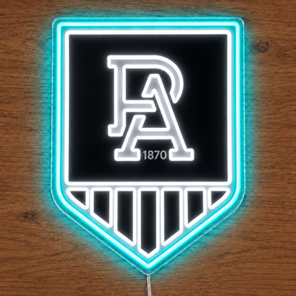 Port Adelaide Power neon sign glowing brightly on a wooden surface in dim lighting