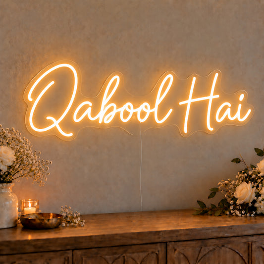 Qabool Hai Neon Sign on clear cut-to-shape acrylic, illuminated on a wall in a styled celebration setting