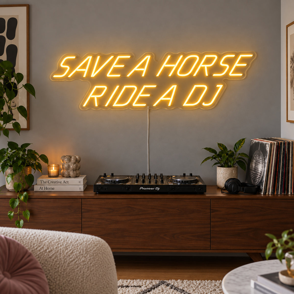 Save A Horse Ride A DJ Neon Sign glowing gold above a turntable on a wooden sideboard.