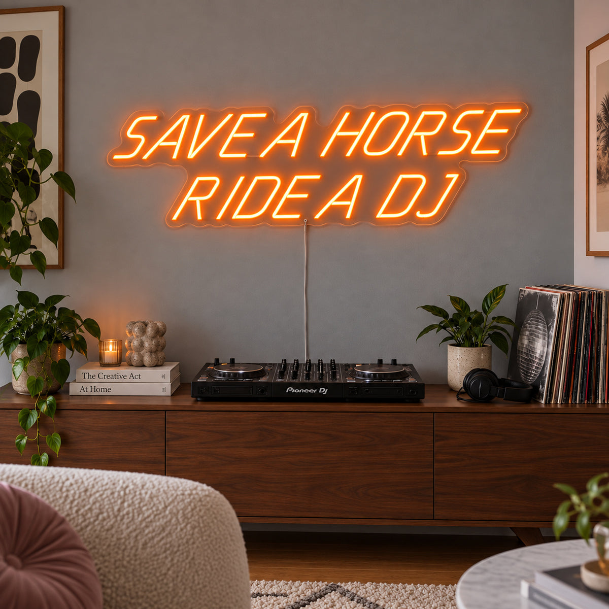 Orange version of the Save A Horse Ride A DJ Neon Sign, shown above a turntable on a wooden sideboard.