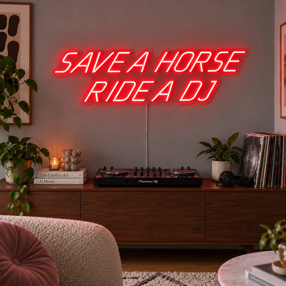 Save A Horse Ride A DJ Neon Sign with red lighting, displayed above a turntable on a wooden sideboard.