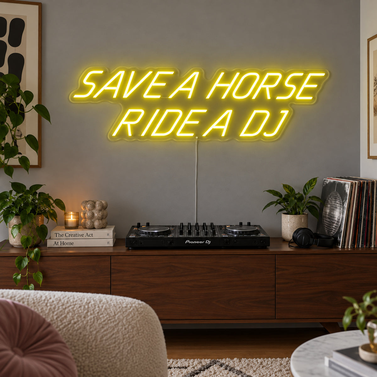 Save A Horse Ride A DJ Neon Sign with yellow lighting, displayed above a turntable on a wooden sideboard.