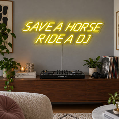 Save A Horse Ride A DJ Neon Sign with yellow lighting, displayed above a turntable on a wooden sideboard.