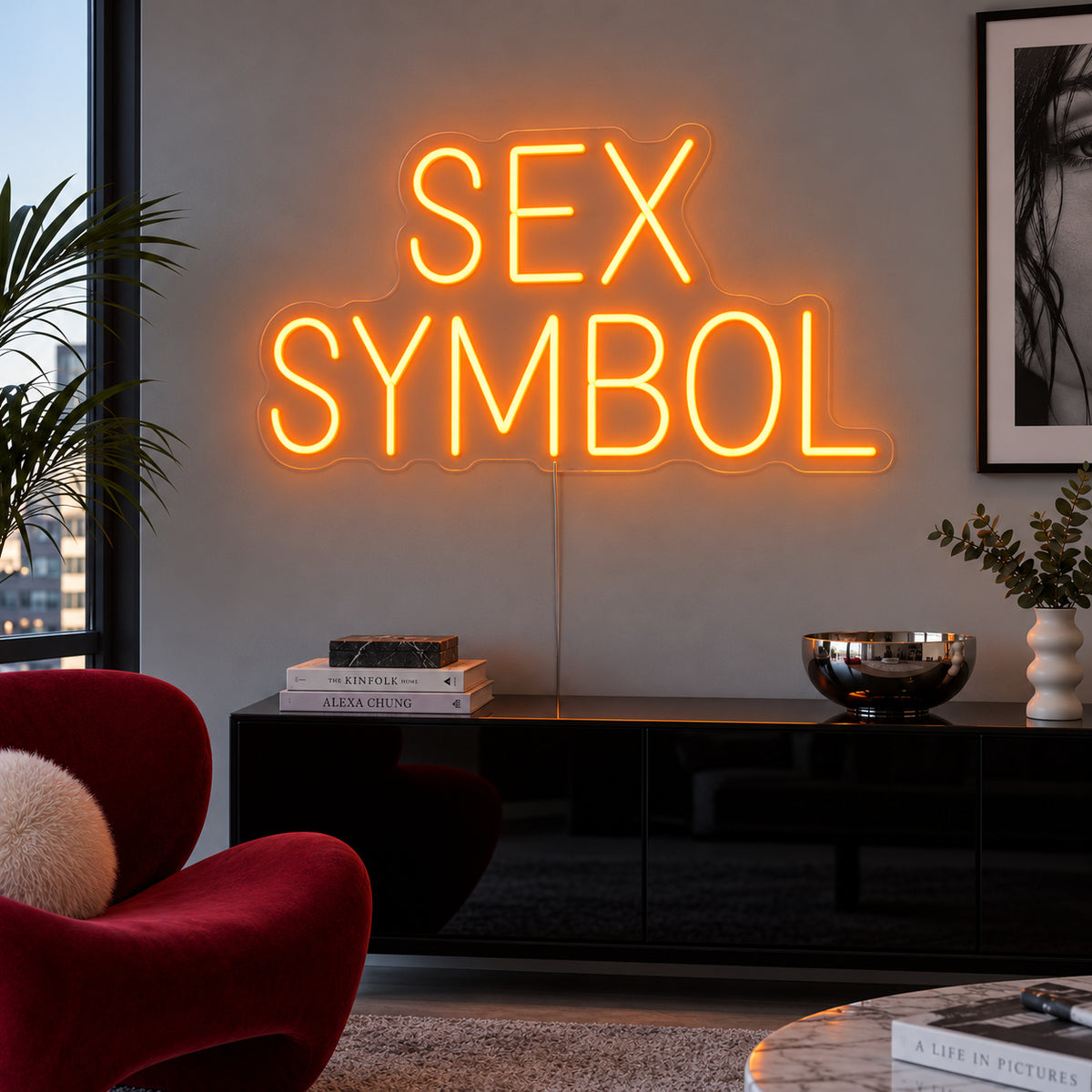 Orange version of the Sex Symbol Neon Sign, shown above a black sideboard.