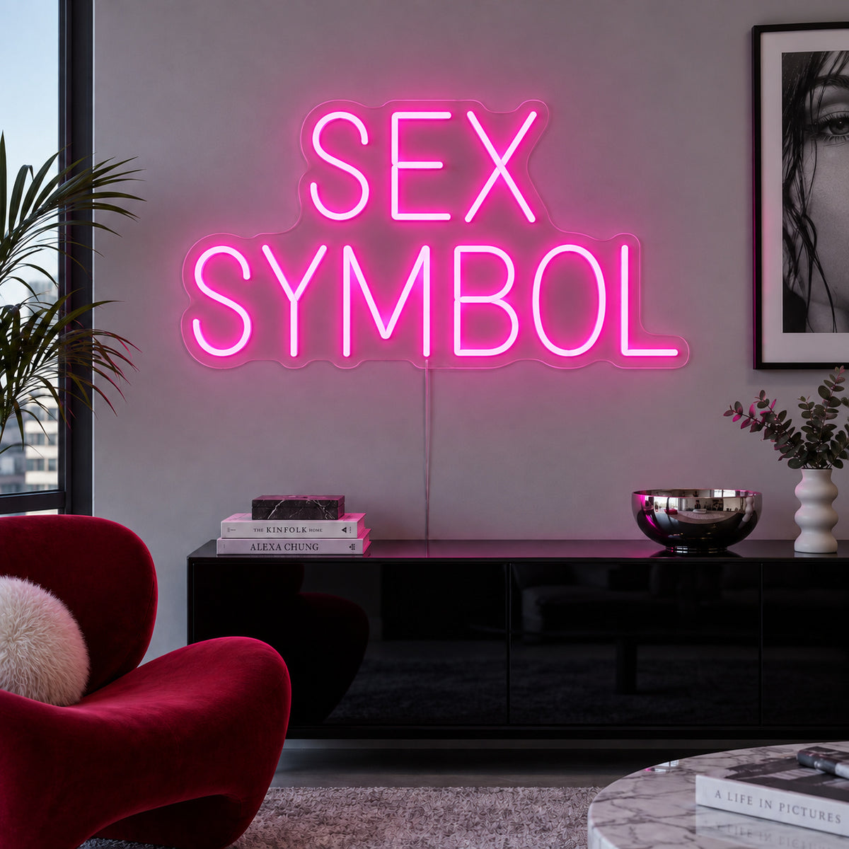Rose Red version of the Sex Symbol Neon Sign, shown above a black sideboard.