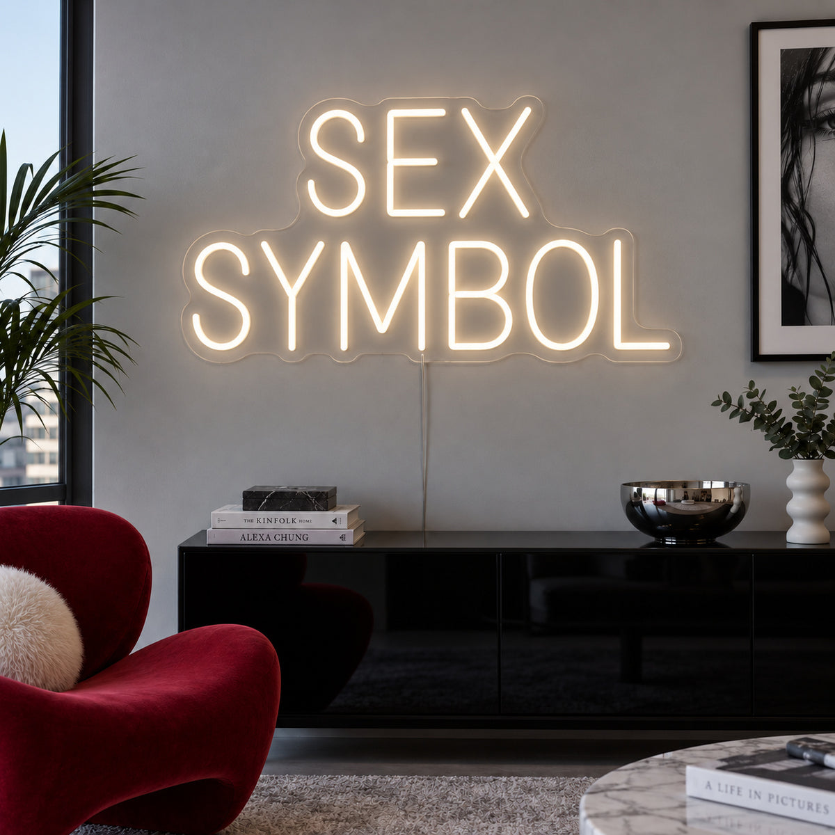Warm White version of the Sex Symbol Neon Sign, shown above a black sideboard.