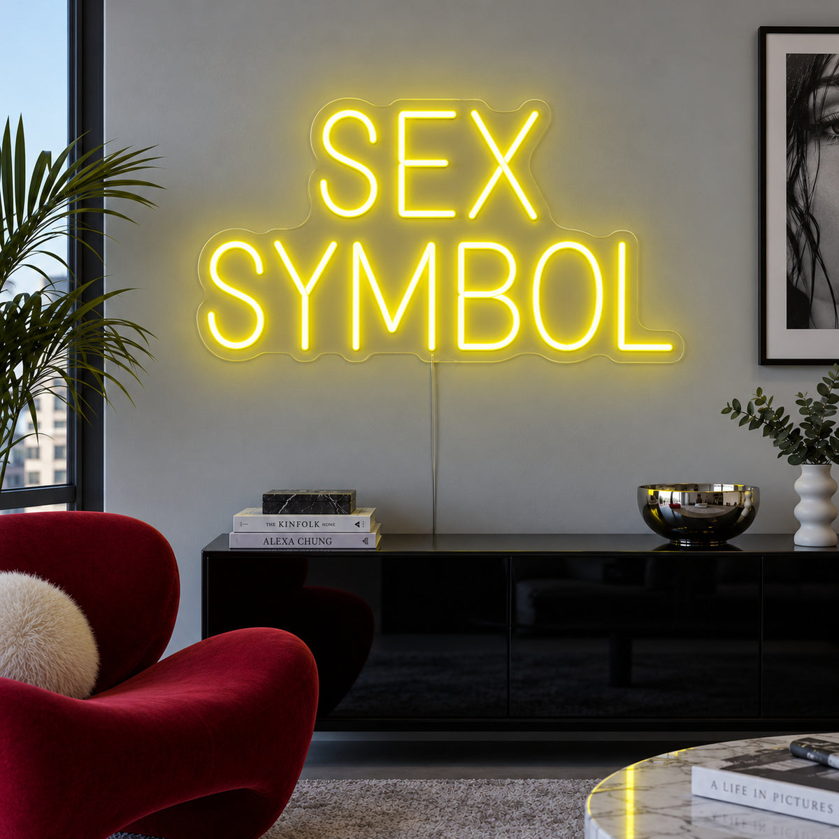Sex Symbol Neon Sign with yellow lighting, displayed above a black sideboard.