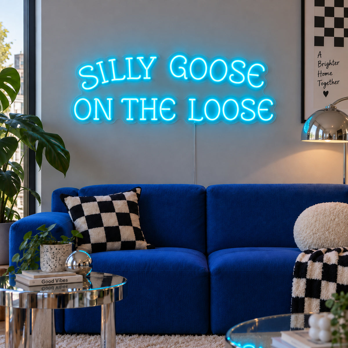 Ice Blue version of the Silly Goose On The Loose Neon Sign, shown above a blue sofa with checkered cushions.
