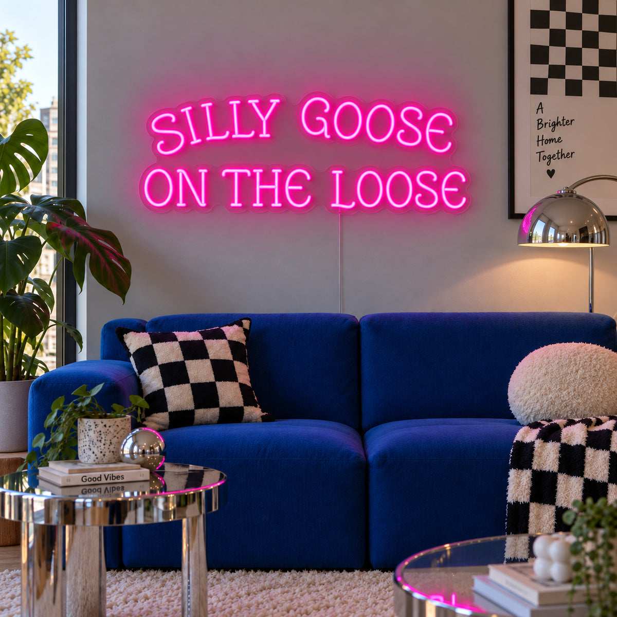 Rose Red version of the Silly Goose On The Loose Neon Sign, shown above a blue sofa with checkered cushions.