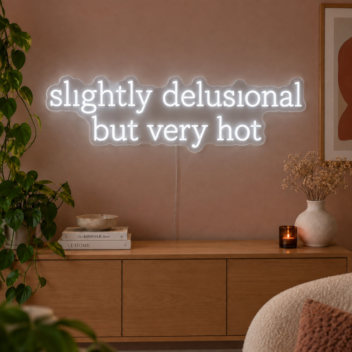 Slightly Delusional But Very Hot Neon Sign glowing white above a wooden sideboard.