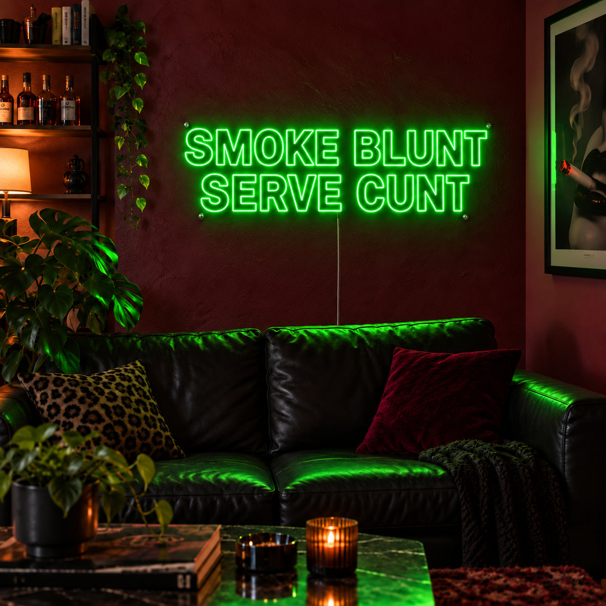 Smoke Blunt Serve Cunt Neon Sign with green lighting, displayed above a black leather sofa.