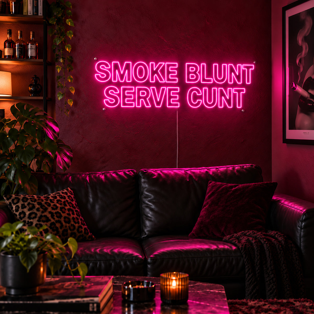 Smoke Blunt Serve Cunt Neon Sign glowing pink above a black leather sofa.