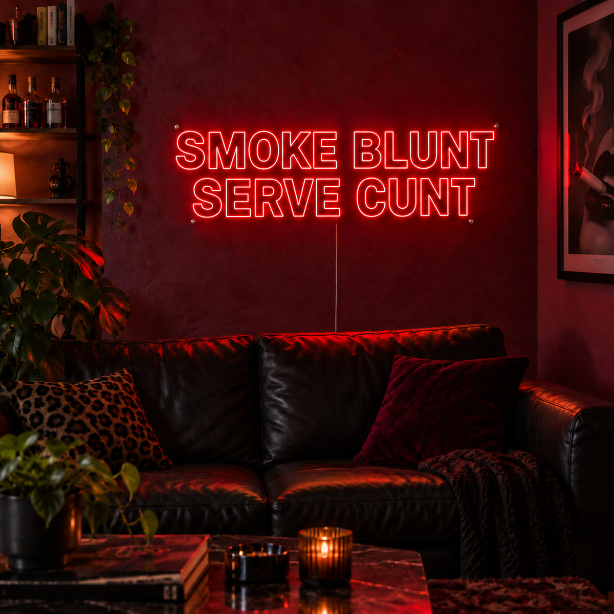 Smoke Blunt Serve Cunt Neon Sign in red above a black leather sofa.