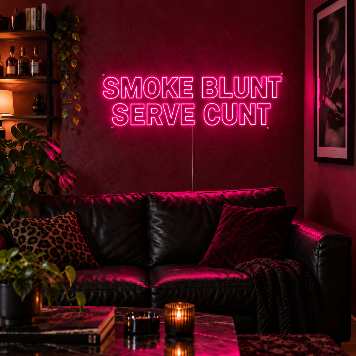 Rose Red version of the Smoke Blunt Serve Cunt Neon Sign, shown above a black leather sofa.