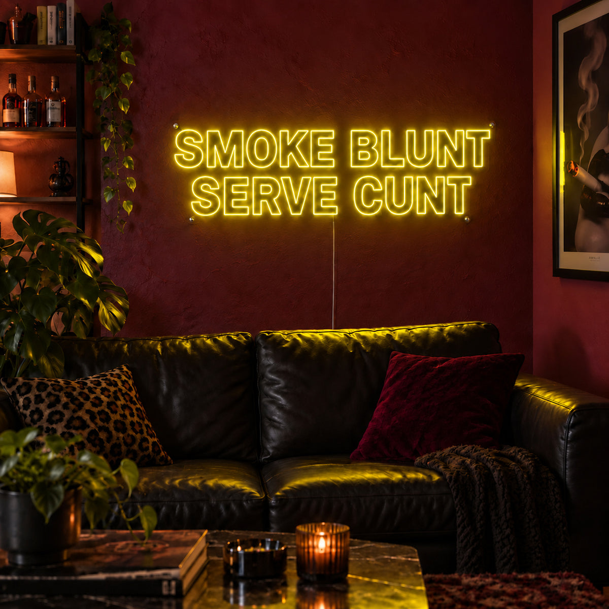 Smoke Blunt Serve Cunt Neon Sign with yellow lighting, displayed above a black leather sofa.