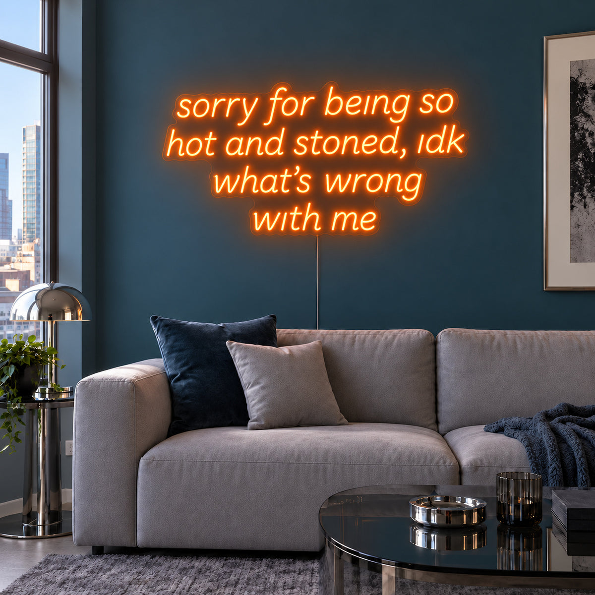Orange version of the Sorry For Being So Hot And Stoned, Idk What's Wrong With Me Neon Sign, shown above a grey sofa against a blue wall.