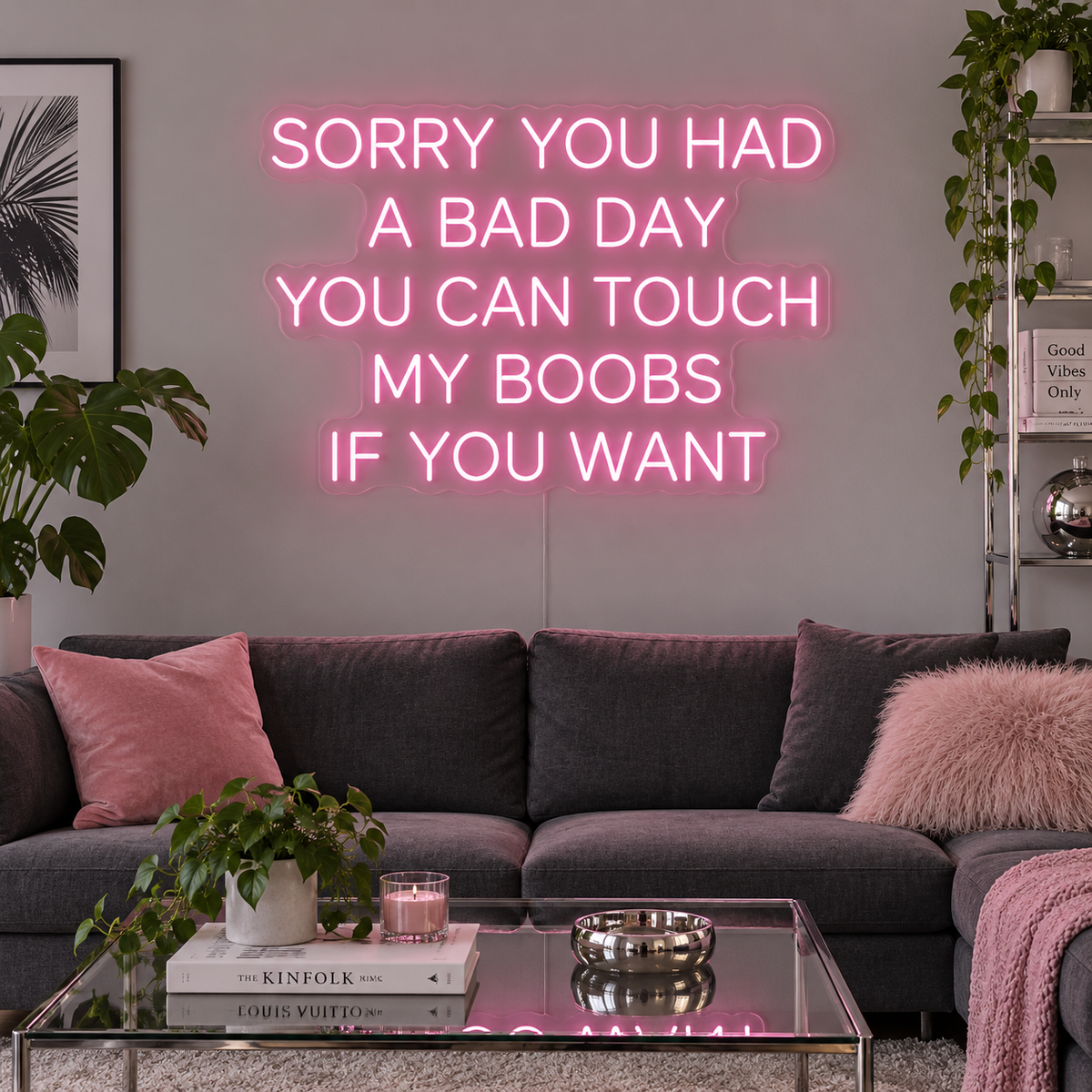 Sorry You Had A Bad Day You Can Touch My Boobs If You Want Neon Sign in pink above a grey sofa with pink cushions.