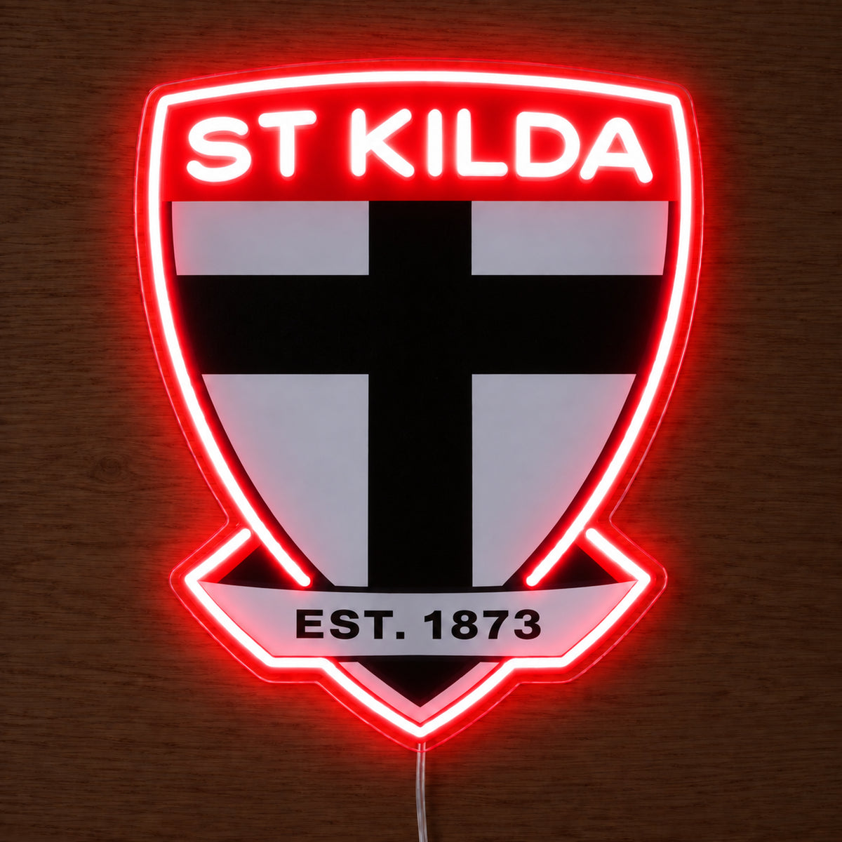 St Kilda Saints neon sign glowing brightly on a wooden surface in dim lighting