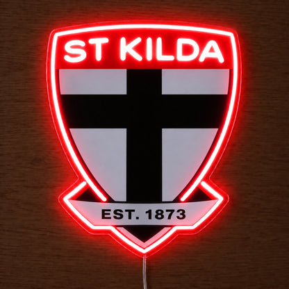 St Kilda Saints neon sign glowing brightly on a wooden surface in dim lighting