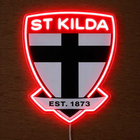 St Kilda Saints neon sign glowing brightly on a wooden surface in dim lighting