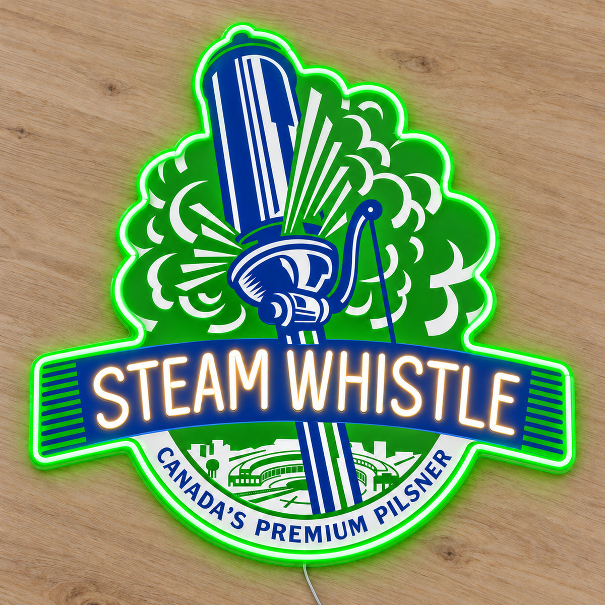 Steam Whistle LED neon sign with a continuous green border and illuminated lettering on a light wooden surface, first angle