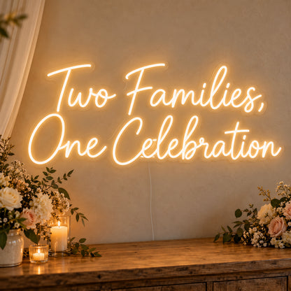 Two Families One Celebration Neon Sign on clear cut-to-shape acrylic, illuminated on a wall in a styled celebration setting