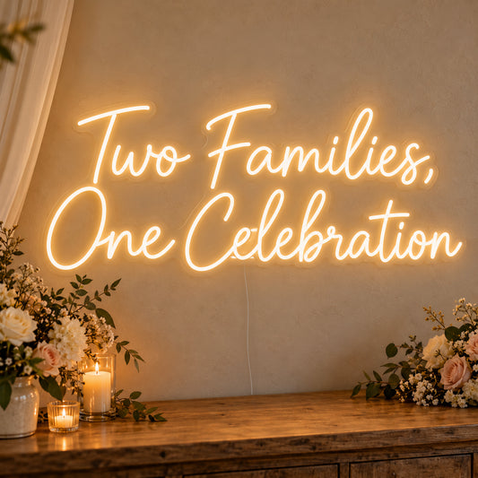 Two Families One Celebration Neon Sign on clear cut-to-shape acrylic, illuminated on a wall in a styled celebration setting